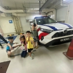 ONE students posing by a police car on their learning journey